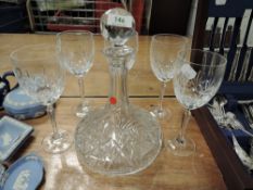 A cut glass decanter and five glasses.