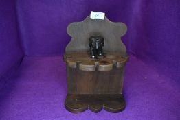 A vintage tobacco smokers pipe rack having colonial style elephant decoration in a Mahogany style