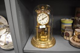 A vintage brass anniversary clock having glass dome and enamel face,marked for Badische.