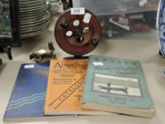 Three vintage fishing books and and antique brass fishing reel and similar wooden reel.