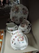 A partial tea set containing cups and saucers, side plates, cake plate, jug and sugar basin having