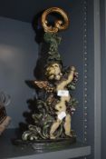 A modern door stop in the form of a cherub and grape vines