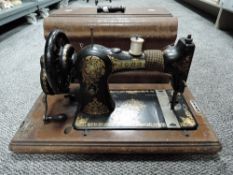 A vintage Jones 75757 crank handled sewing machine in wooden case.