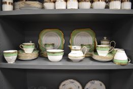 A part tea service by Gladstone china having a green and gilt glaze with a similar French porcelain