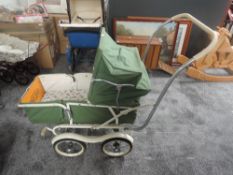 A 1960's TanSad Dolls Pram genuine model 322 having green canopy hood with cream interior on twin