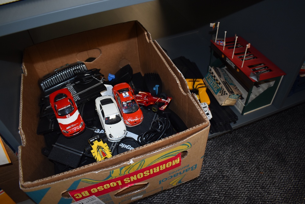 A shelf of moden Scalextric track, cars and controllers along with a empty early box C-82 Lotus