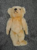 A 1950's Straw filled yellow plush Teddy Bear having plastic eyes, stitched nose and mouth,