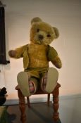 A mid 20th century yellow plush Teddy Bear having stitched nose and mouth, jointed body and