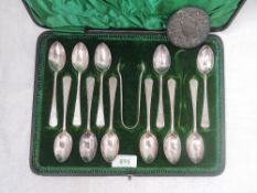 A cased set of twelve Victorian (1 spoon missing) silver teaspoons with matching sugar nips having