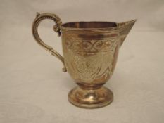 A Victorian cream jug having extensive panelled decoration with monogrammed cartouche and moulded