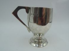 A silver Christening mug of plain stylised form bearing name to front & having angular handle,