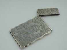 A Victorian silver card case having extensive engraved scroll decoration, monogrammed cartouche