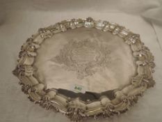 An Edwardian silver salver having moulded raised pie crust rim, trefoil bracket feet and central