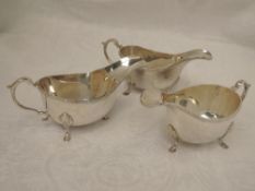 A trio of silver sauce boats having reed and sprig decoration to rim, trefoil hoof feet and