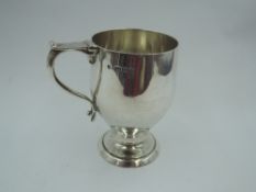 A silver Christening mug of plain stylised form bearing name to front & having angular loop