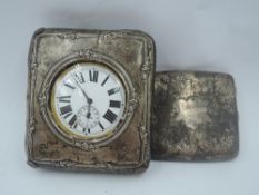 A silver watch stand/case having floral decoration to silver front and leather bound back (missing