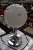 A vintage style table lamp having opaque spherical shade and chrome frame