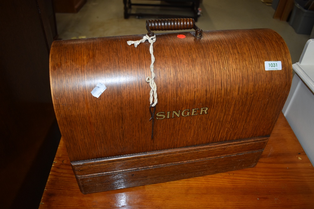 A vintage Singer sewing machine, in oak dome top case