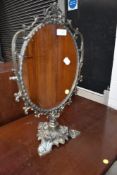 An early 20th Century ornate brass toilet mirror