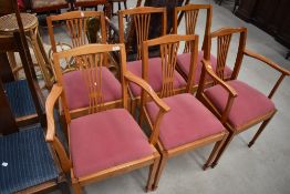 A set of six (four plus two) light stained dining chairs having feather style slat back, upholstered