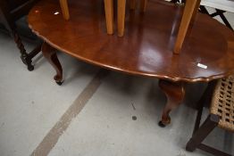 A reproduction coffee table having shaped top, cabriole legs and castors, width approx. 116cm