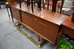 A vintage teak long john style sideboard having central drawer section and sliding doors to side