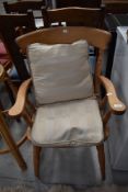 A traditional beech frame kitchen carver chair with loose cushions