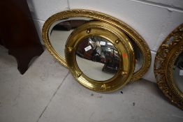 A vintage brass circular mirror and a gilt frame oval mirror