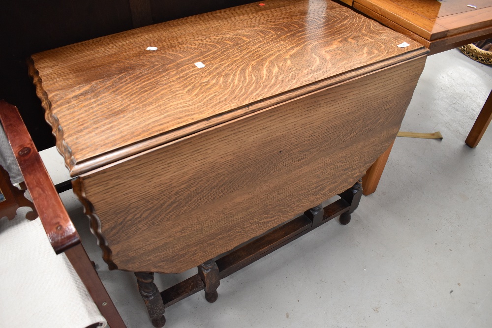 An early 20th Century gateleg dining table having shaped top and barley twist frame