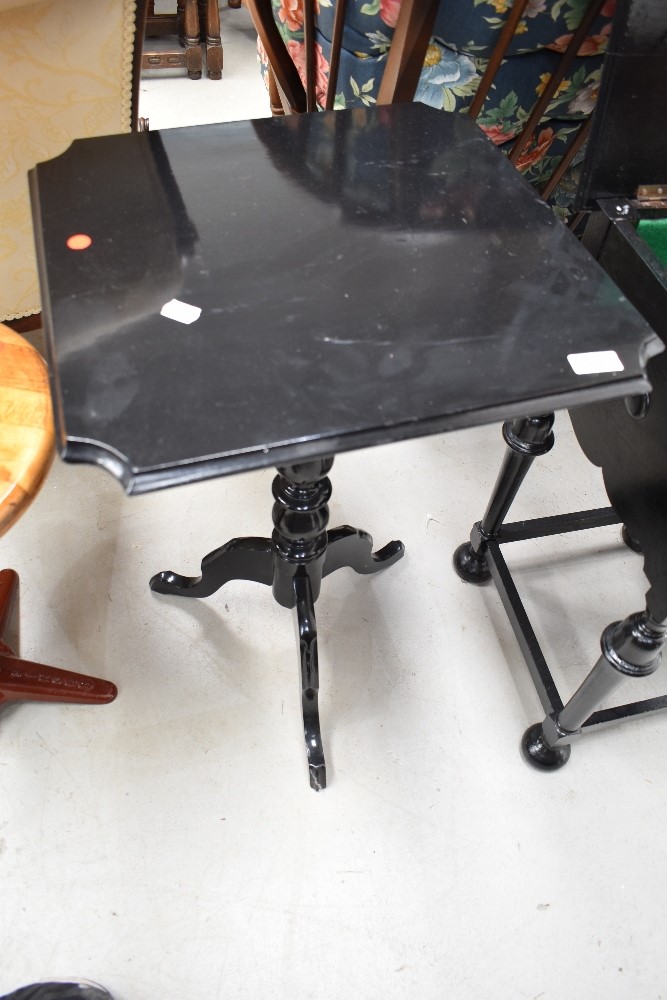 A Victorian style black painted snap top occasional table, having turned column and triple splay