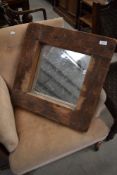 A rustic wood wall mirror of chunky form, width approx. 51cm