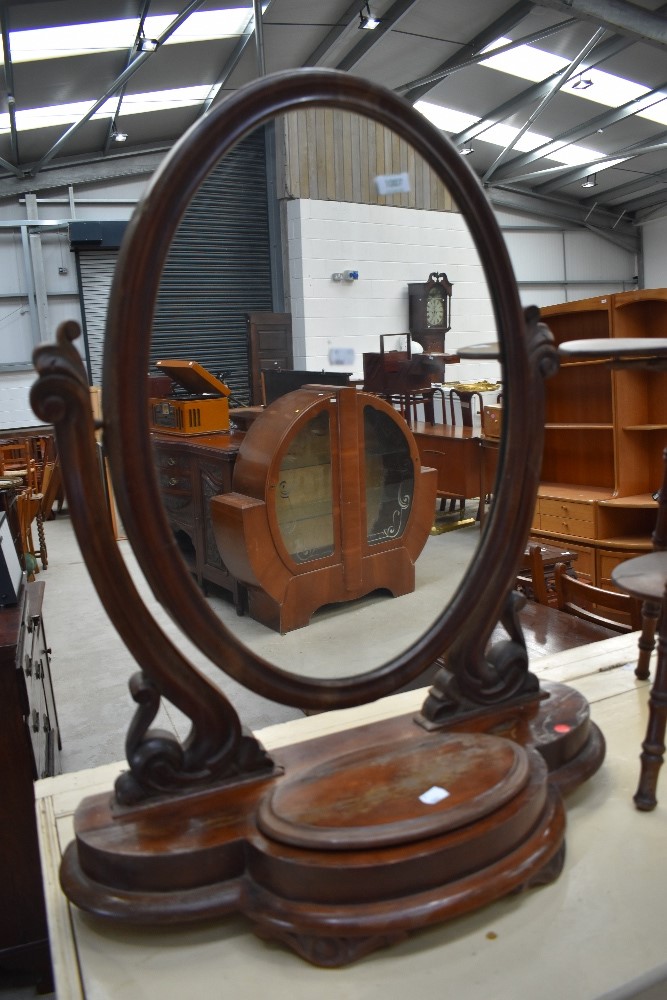 A Victorian mahogany toilet mirror having scroll frame and trinket base