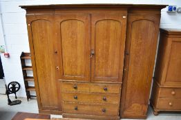 A 19th Century scumbled pine breakfront wardrobe having central linen press section , two over three