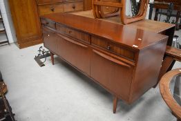 A vintage long john style sideboard, mixed woods, having triple frieze drawers, drop flap centre
