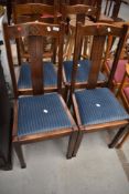 A set of four early 20th Century stained frame rail back dining chairs having later drop in seats