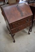 A reproduction mahogany bureau on Queen Anne style cabriole legs