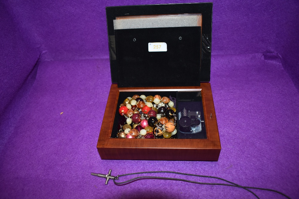 A selection of costume jewellery necklace of beaded form and a musical case