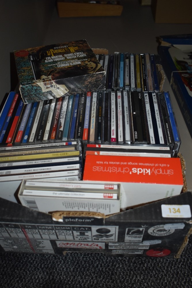 A box of mixed compact discs.