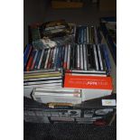 A box of mixed compact discs.