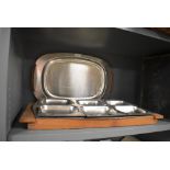 A selection of stainless steel dinner and party serving trays including wooden teak stand