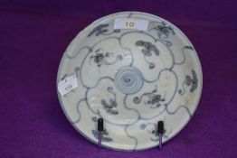 A Chinese footed dish having a celadon style glaze with blue geometric styled design on footed base