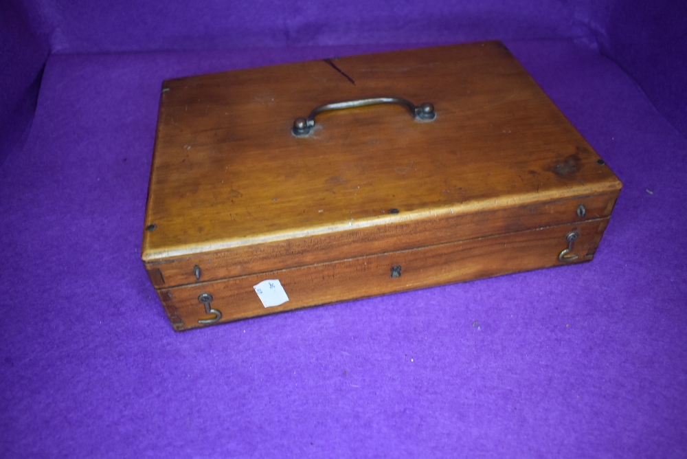 A mid century wooden box containing a number of pencils and stationary