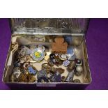 A vintage Riley's toffee tin containing a selection of badges and pins including several Girl
