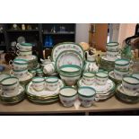 A large partial antique dinner service having hand tinted floral pattern, green banding and gilt