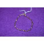 A yellow metal bracelet having hoop form links stamped 9kt