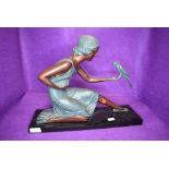 A reproduction art deco figure of a lady holding a parrot