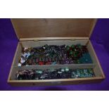 A wooden box containing a selection of beaded necklaces, bracelets and book marks