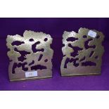 a pair of fold out brass book ends chased with Chinese dragon image