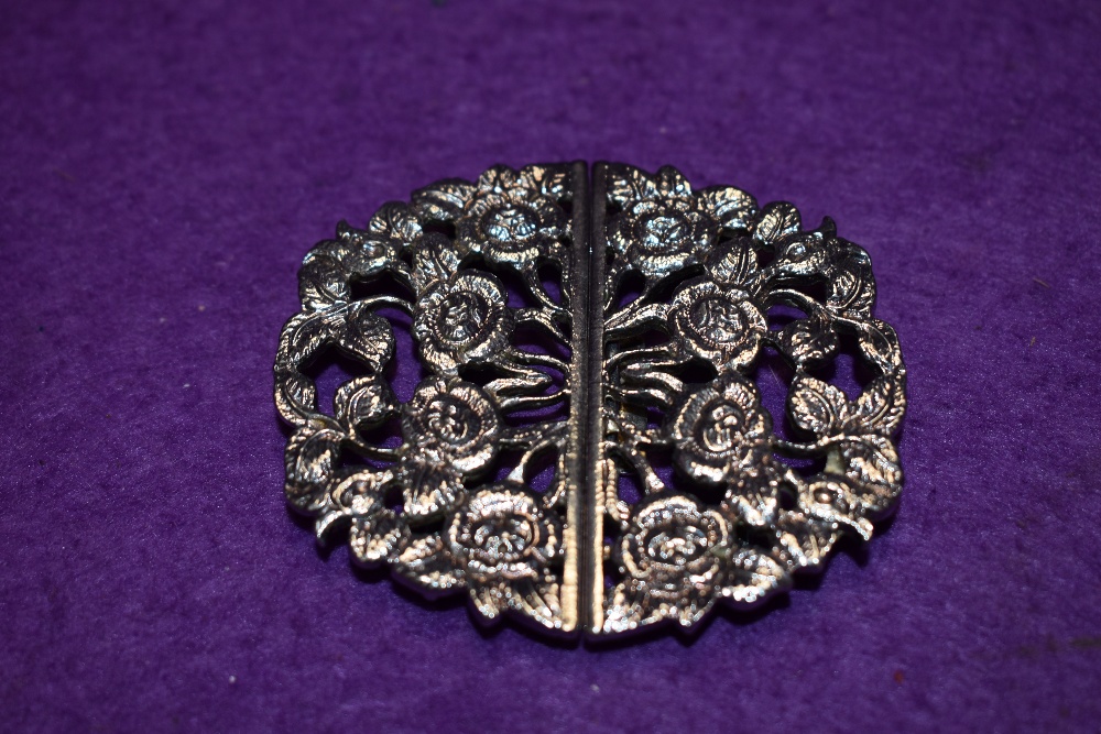 A silver plated nurses buckle having floral moulded decoration