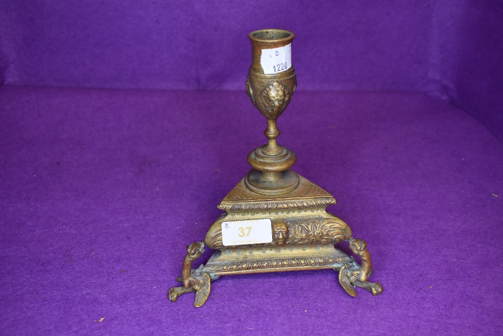 A bronze candle stick having a neo classical design with triangle design on dragon feet with green